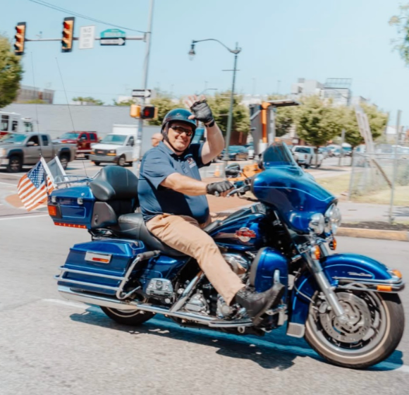 DiBello riding his motorcyle in the escort of the wall of healing.